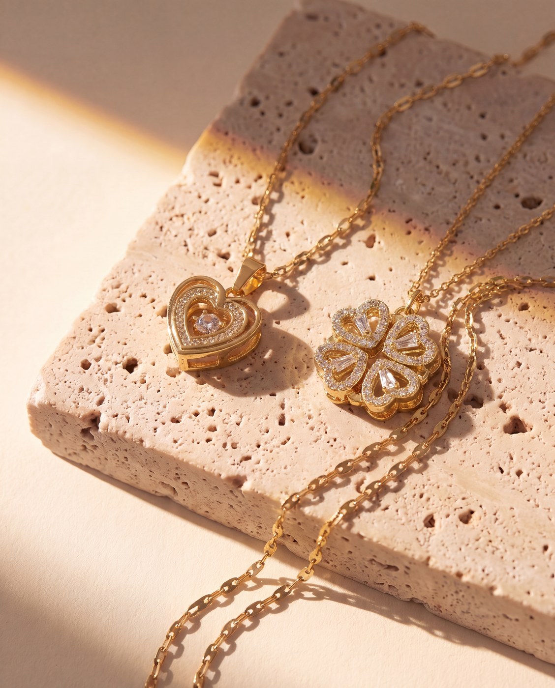 Gold necklace set arranged on a travertine slab in warm light